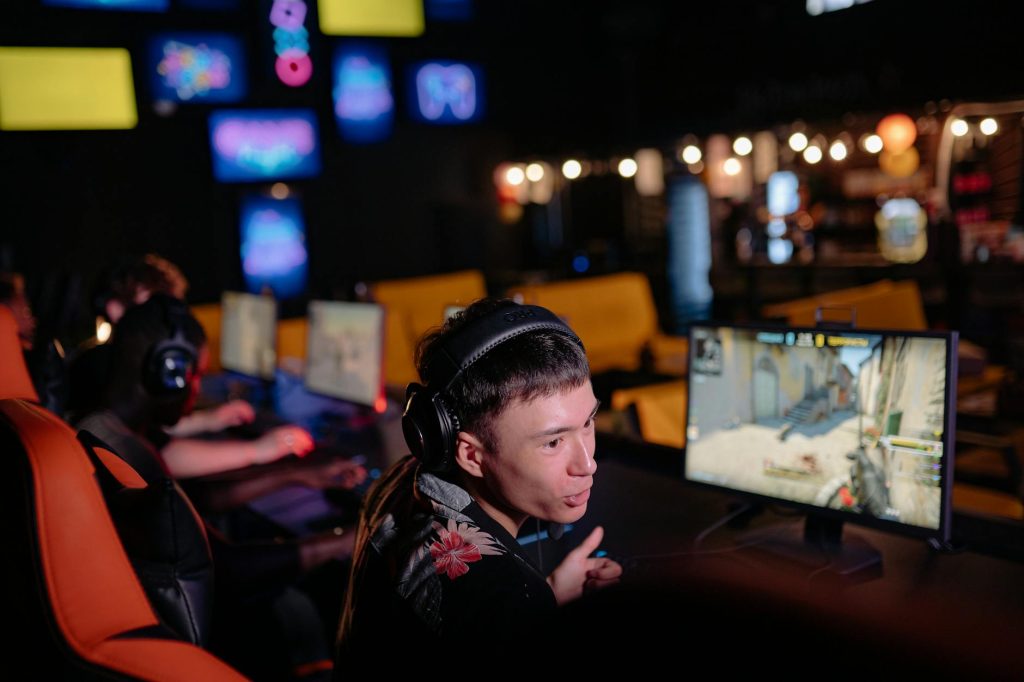 Game thủ tập trung thi đấu e-sport online với tai nghe trong góc chơi gọn gàng